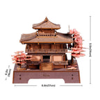 Wooden model of a Japanese temple with cherry blossom trees and measurements on a white background