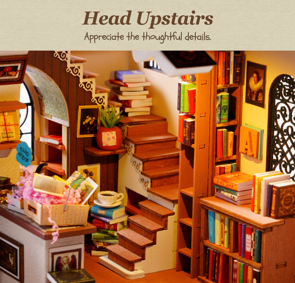 A miniature dollhouse-style interior scene with a wooden staircase, bookshelves, books, framed pictures, and decorative accessories. Text at the top reads 'Head Upstairs' and 'Appreciate the thoughtful details.