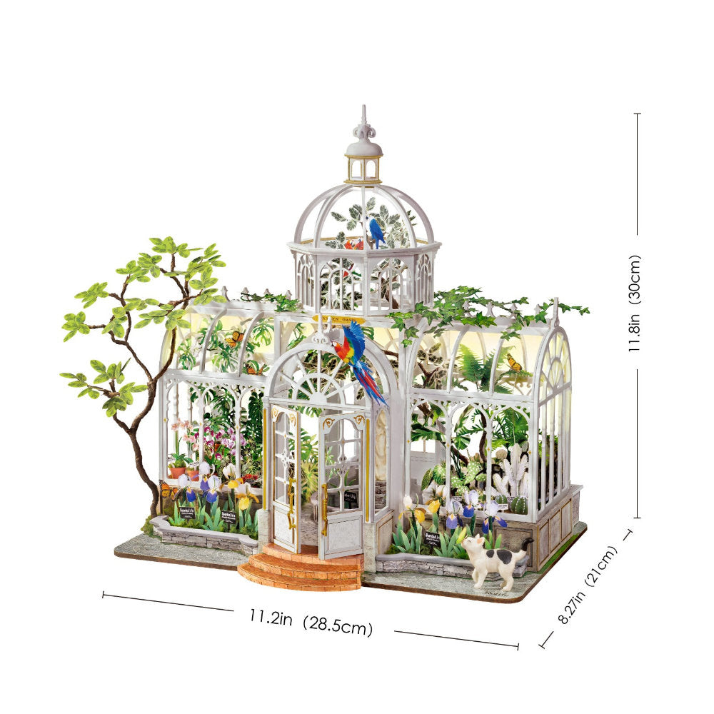 A miniature greenhouse model with a white frame, glass panels, colorful flowers, birds, and small plants, shown with dimension lines and labels indicating width, depth, and height on a white background.