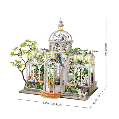 A miniature greenhouse model with a white frame, glass panels, colorful flowers, birds, and small plants, shown with dimension lines and labels indicating width, depth, and height on a white background.