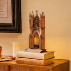 Gothic architecture model on top of books with a warm glow in a cozy room.