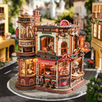 Detailed model of a coffee factory with lit signs and furniture, set against a blurred street background.