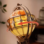 Decorative globe with world map and glowing interior, surrounded by gears.