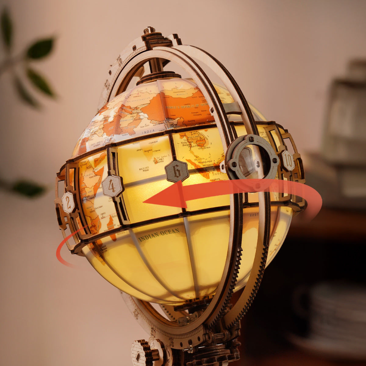 Decorative globe with world map and glowing interior, surrounded by gears.