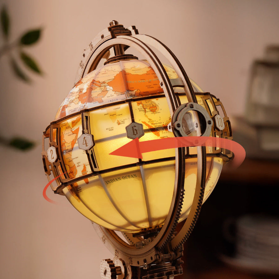 Decorative globe with world map and glowing interior, surrounded by gears.