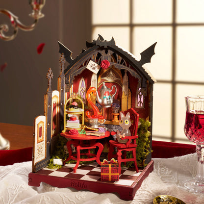 A miniature gothic tea-time diorama set on a checkered base, featuring a red table, chairs, teapot, and rabbit figure, styled on a tablecloth with a glass of red wine in the background.