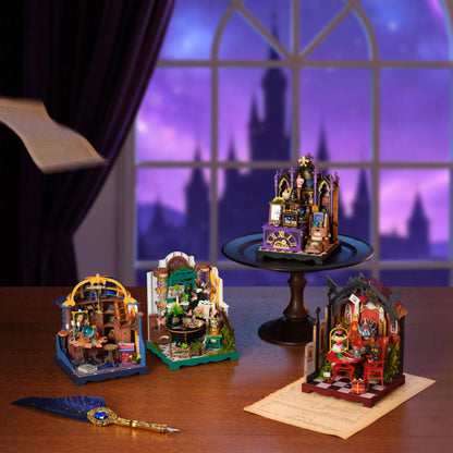 Four miniature wizarding-themed building block sets arranged on a wooden table, with one set displayed on a black pedestal. The scene is styled with a purple castle window backdrop, parchment paper, and a blue feather quill.