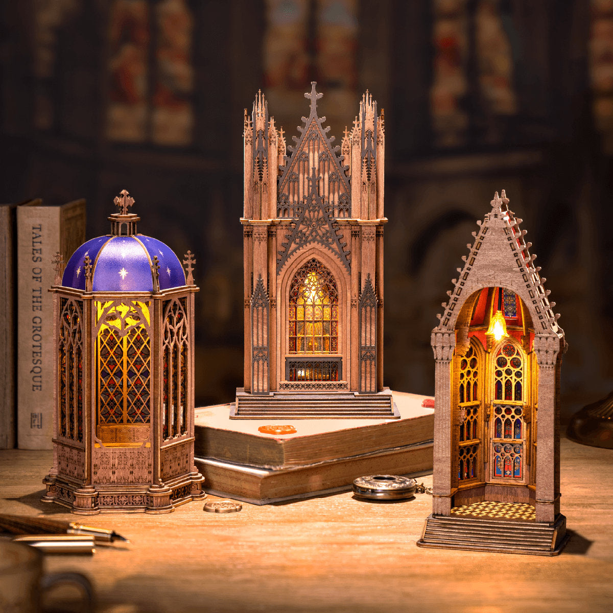 Three gothic-style lanterns on a wooden surface with a blurred background