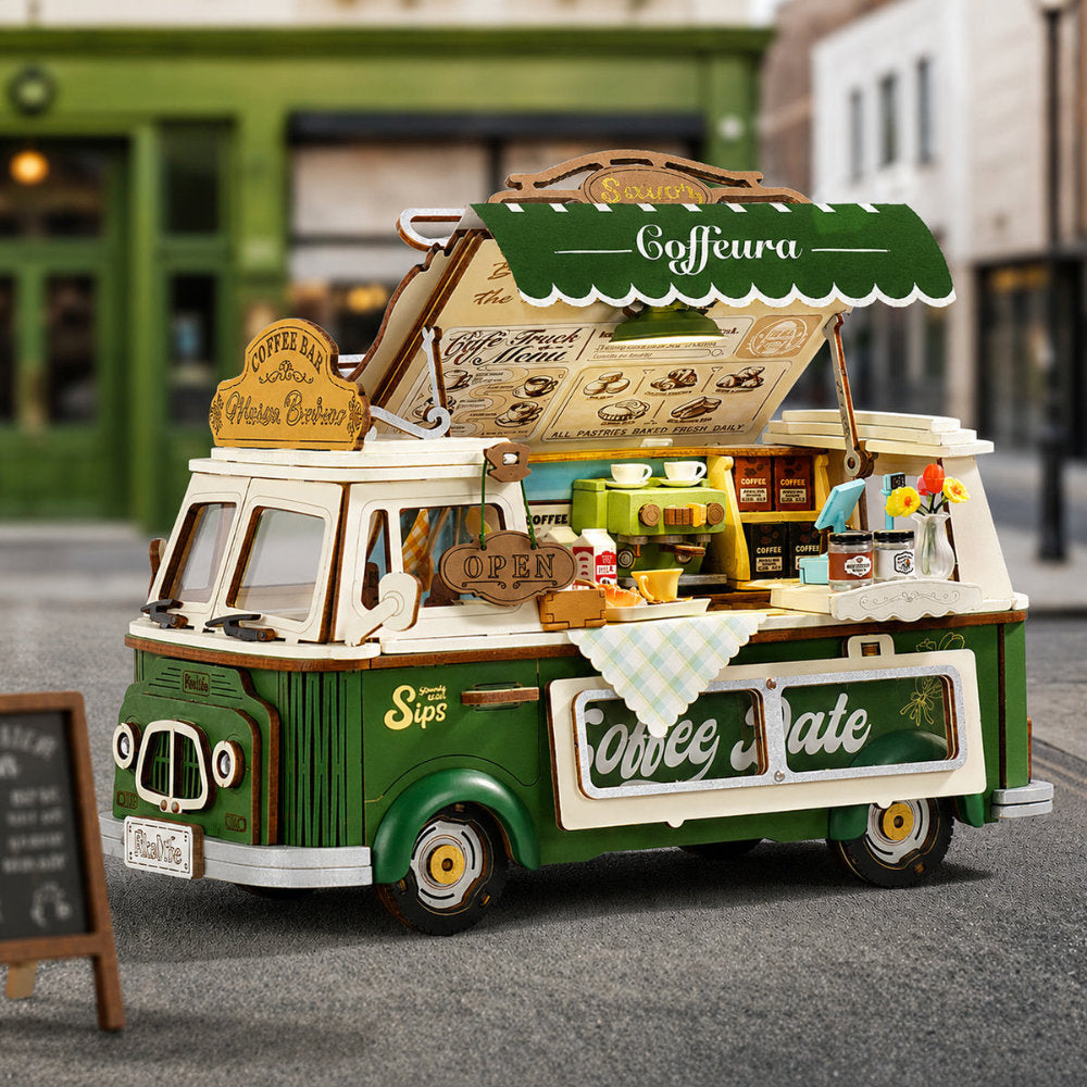 Model of a vintage coffee truck with detailed interior and branding on a blurred street background.