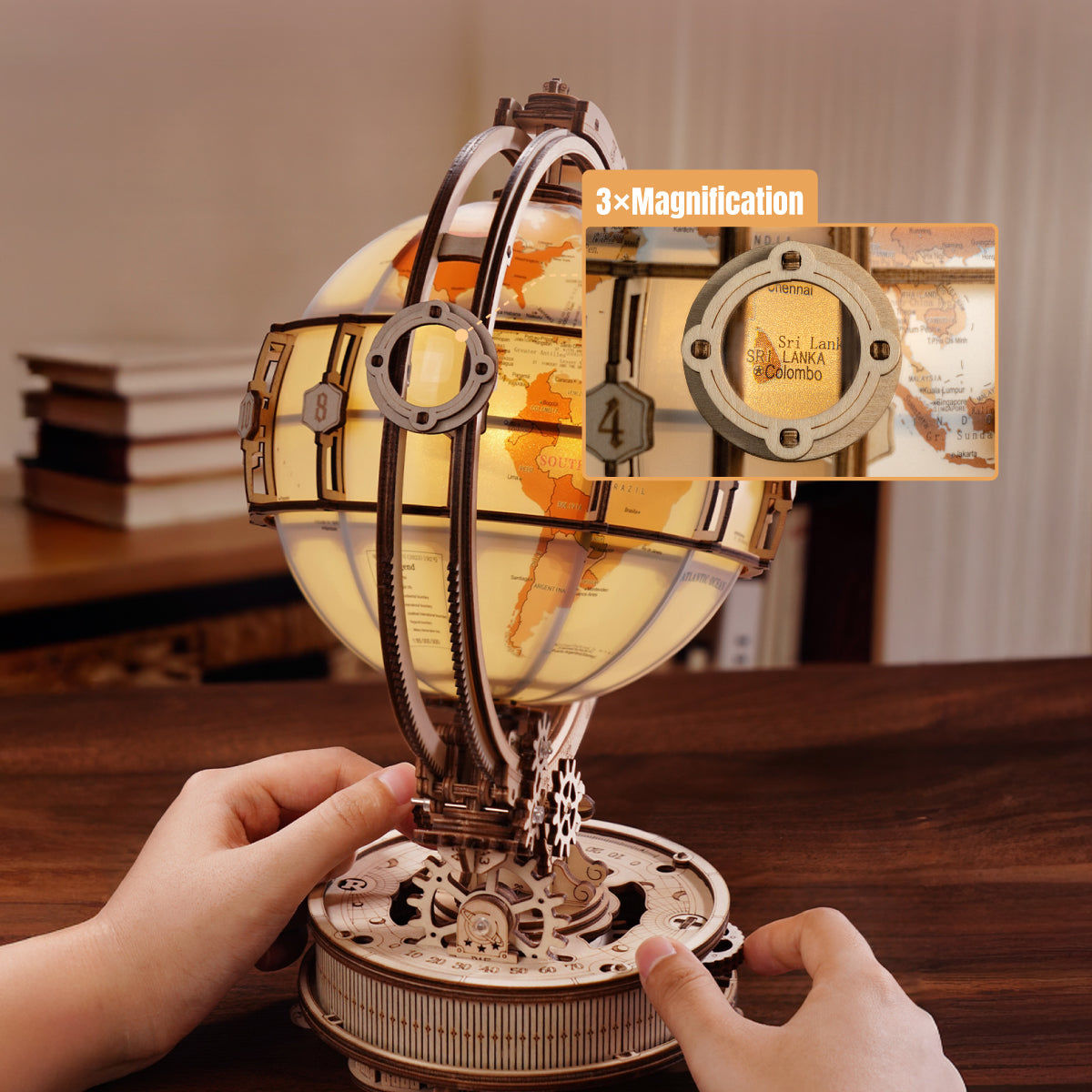 Mechanical model of a globe with gears and a hand interacting with it, on a wooden surface.