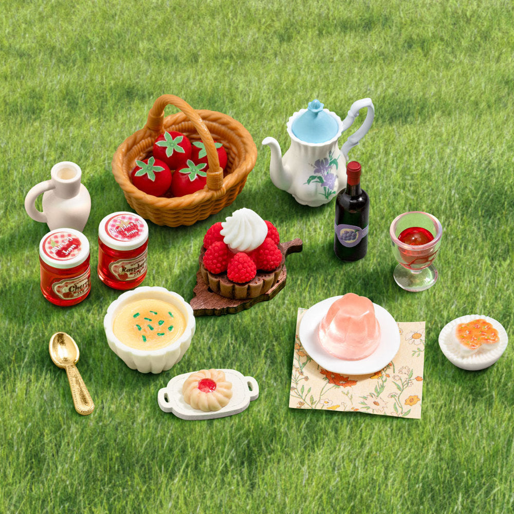 Miniature food items and picnic setup on grass