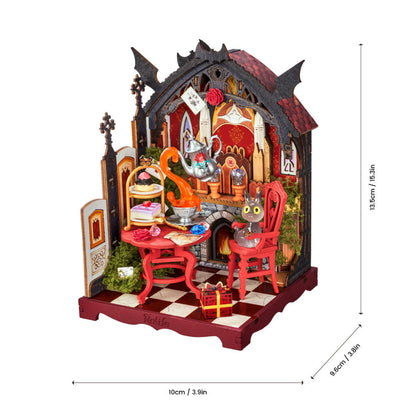 A miniature gothic fantasy tea party diorama with a cat in a red chair, shown with dimension lines indicating 13.5cm height, 10cm width, and 9cm depth on a white background.