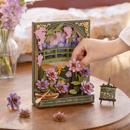 Hand holding a 3D floral book with decorative elements on a wooden table.