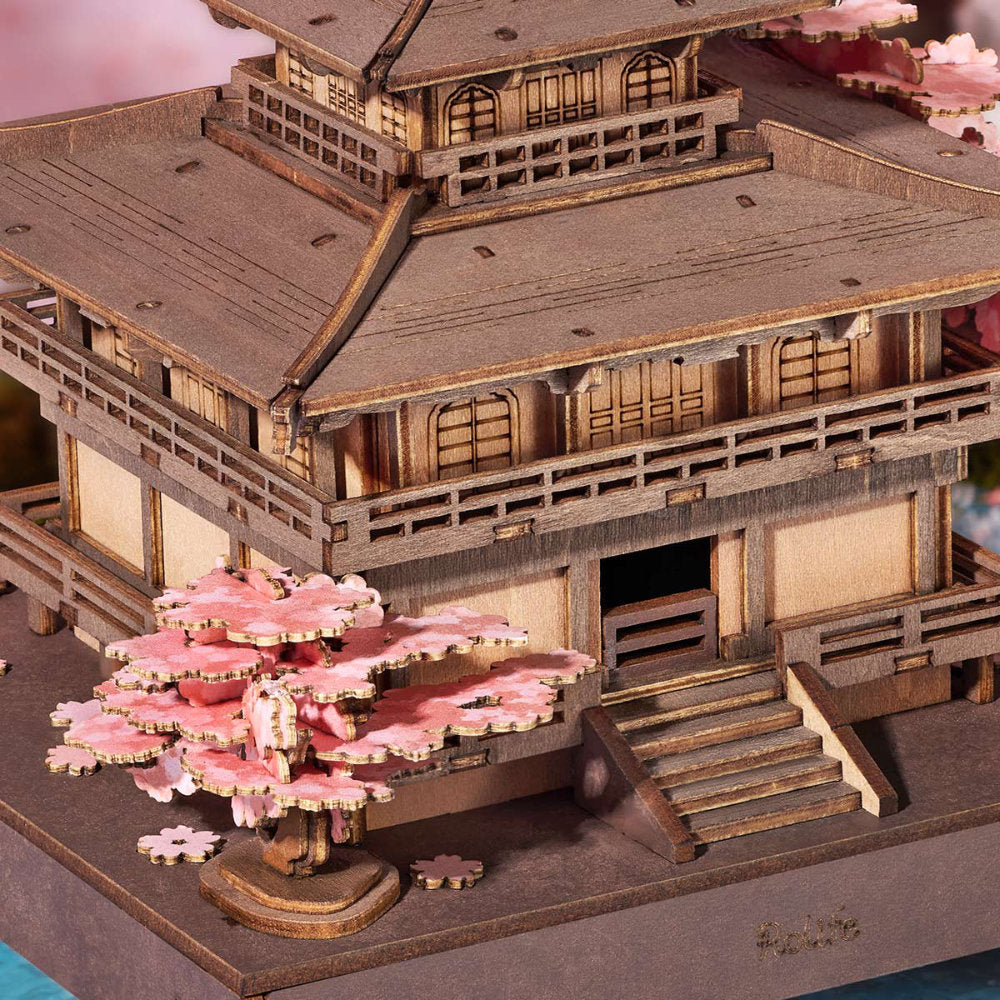 Wooden model of a traditional Japanese building with cherry blossom trees