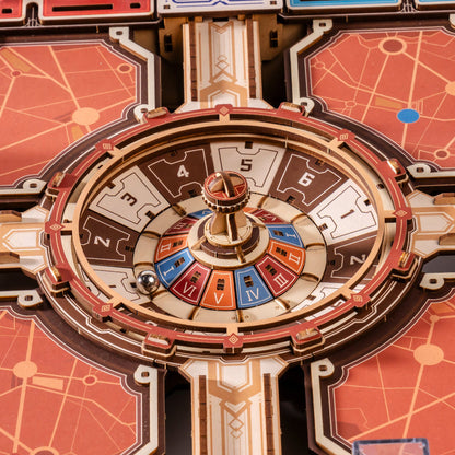 Close-up of a circular game board or spinner wheel with numbered segments 1 through 6, colored blue, red, orange, and brown, surrounded by decorative geometric panels in warm orange, cream, and gold tones.