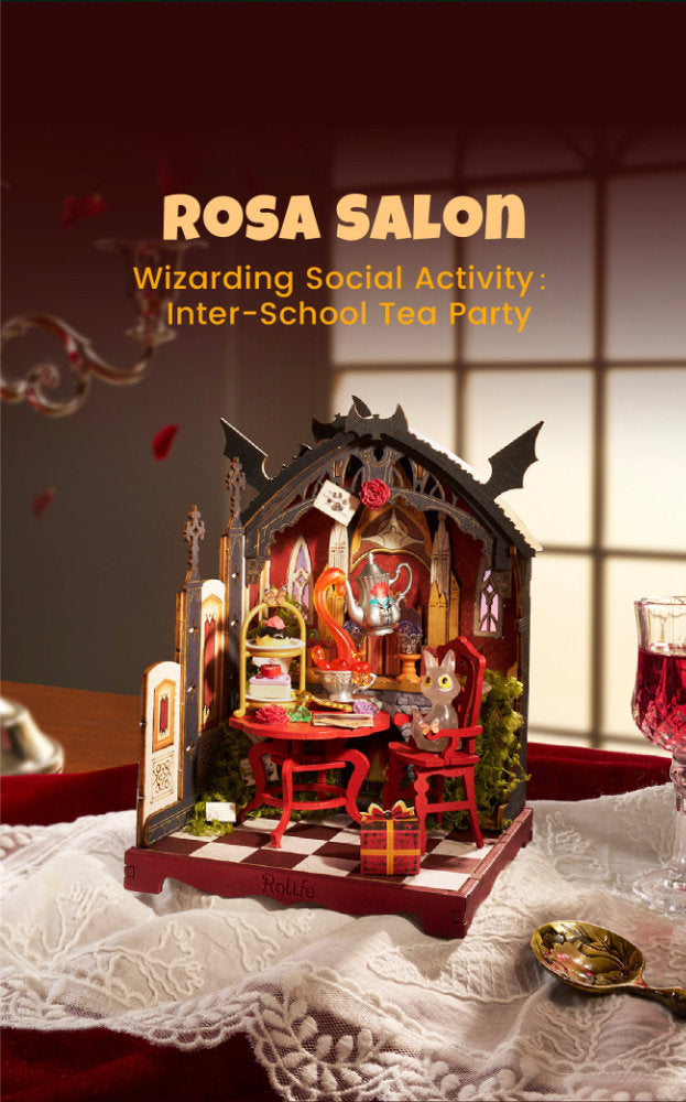 A miniature diorama model of a gothic-style tea salon named 'Rosa Salon', featuring a small checkered table, red chairs, a glass case, and a mouse character, displayed on a white lace cloth with a wine glass in the background.
