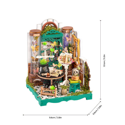 A miniature gothic-style glass jar terrarium diorama with dimension markings showing 9.6cm width, 8.