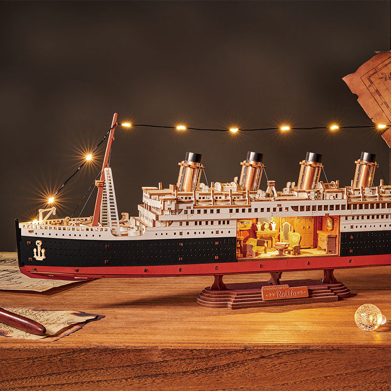 Model of the Titanic on a wooden table with decorative lights in the background