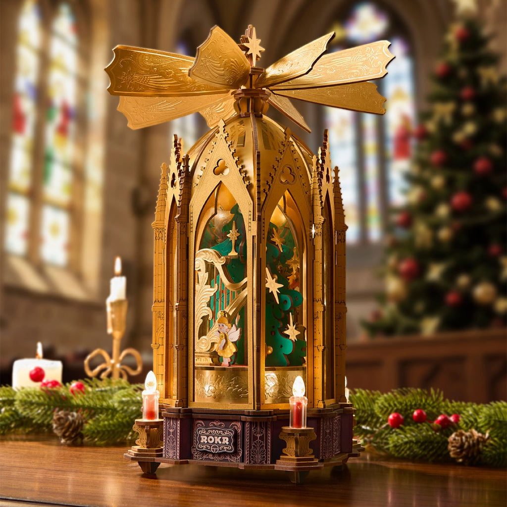 Wooden-Town Angel's Christmas Pyramid 3D wooden puzzle music box – pyramid on a table in a church with stained-glass windows and a Christmas tree