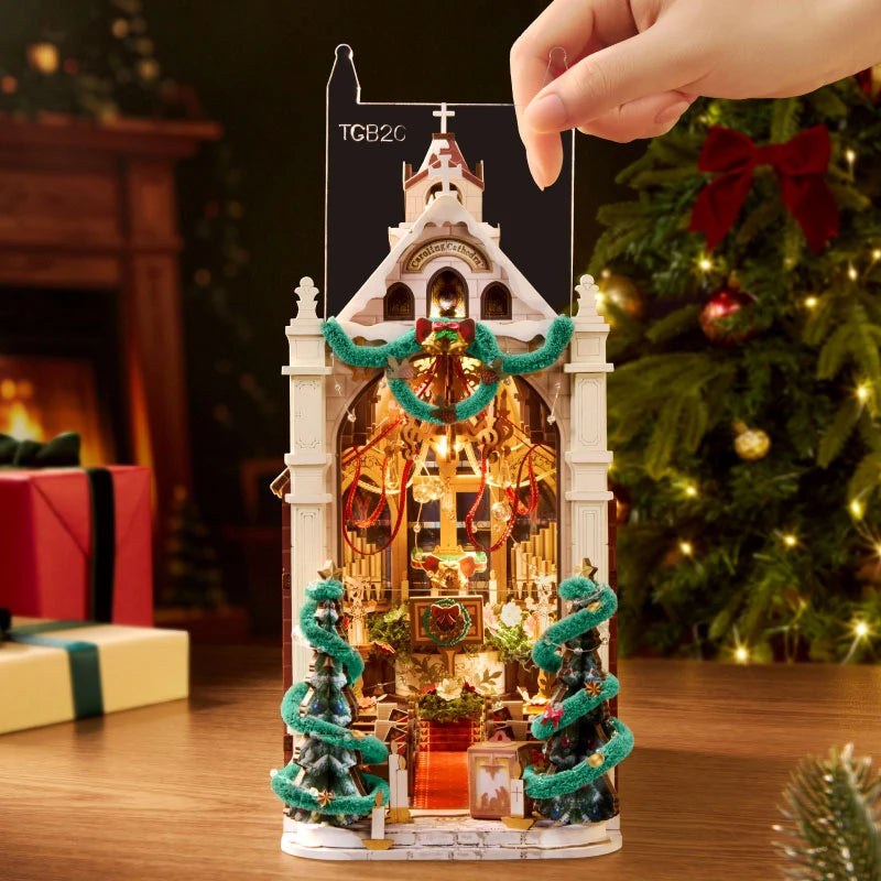 Wooden-Town Caroling Cathedral 3D wooden book nook kit – hand sliding the clear dust cover onto the lit cathedral