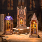 Three gothic-style model buildings with intricate designs on a wooden surface.