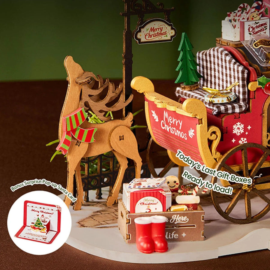 Wooden-Town Reindeer Express DIY miniature kit – close-up of the reindeer in a striped scarf beside a crate of gifts and red boots